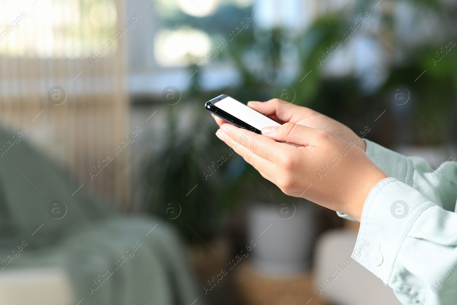 Photo of Closeup view of woman with smartphone indoors. Space for text