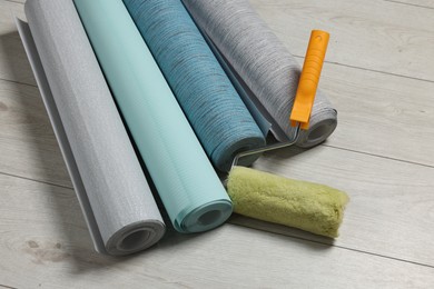 Photo of Different wallpaper rolls and roller on floor