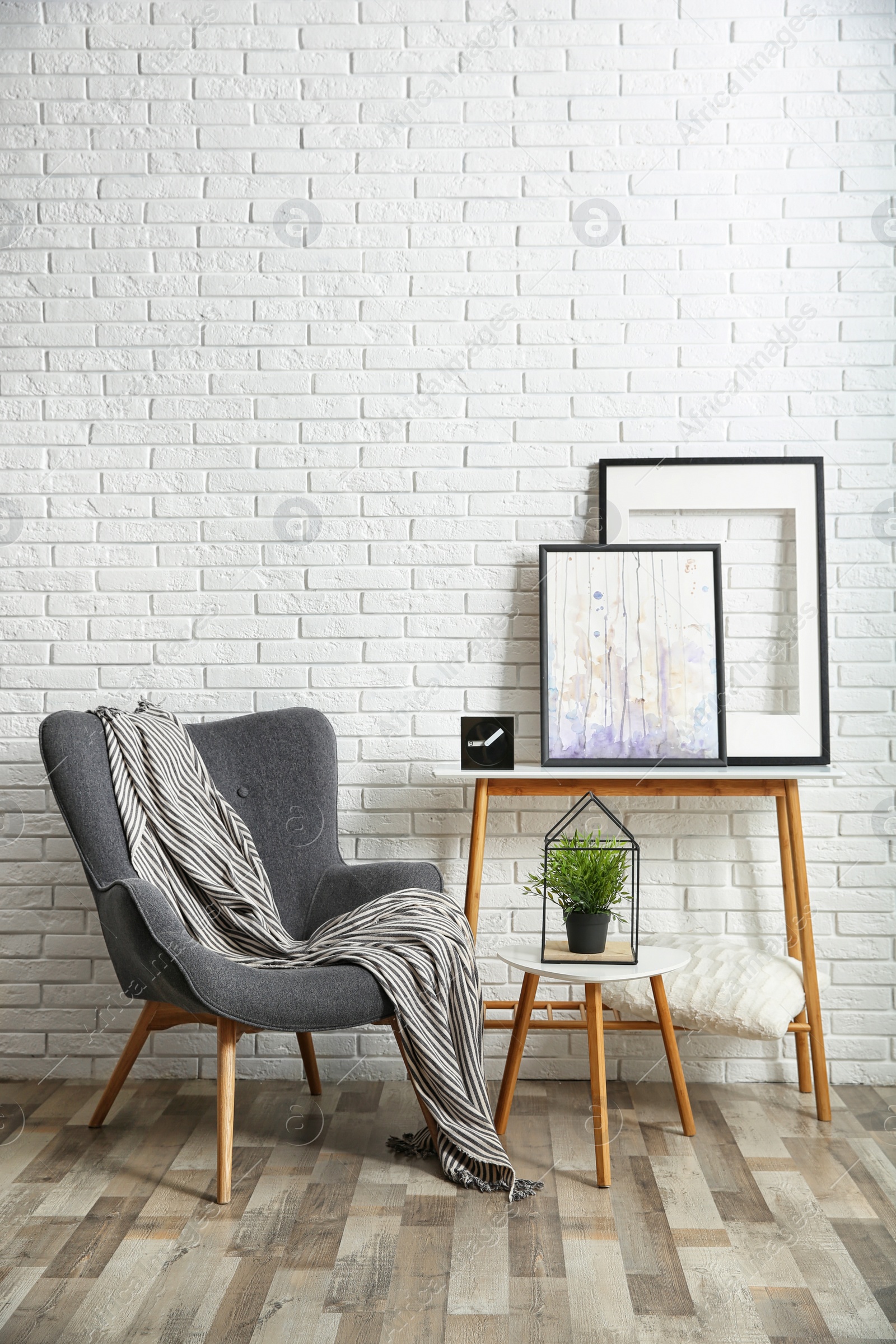 Photo of Stylish living room interior with comfortable armchair near brick wall. Space for text