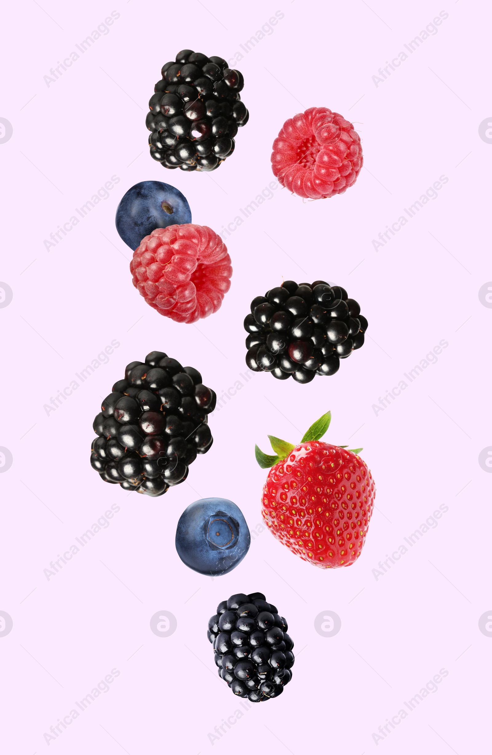 Image of Blackberries, blueberries, strawberry and raspberries falling on pink background