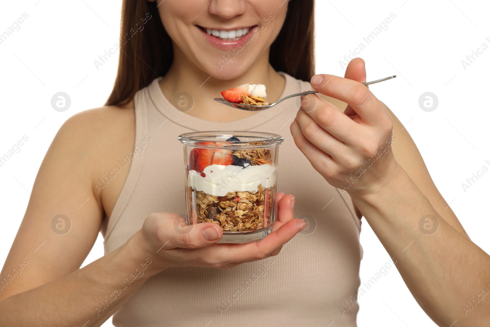 Photo of Happy woman eating tasty granola with fresh berries and yogurt on white background, closeup