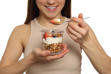 Photo of Happy woman eating tasty granola with fresh berries and yogurt on white background, closeup