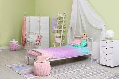 Photo of Cute child's room interior with toys and modern furniture