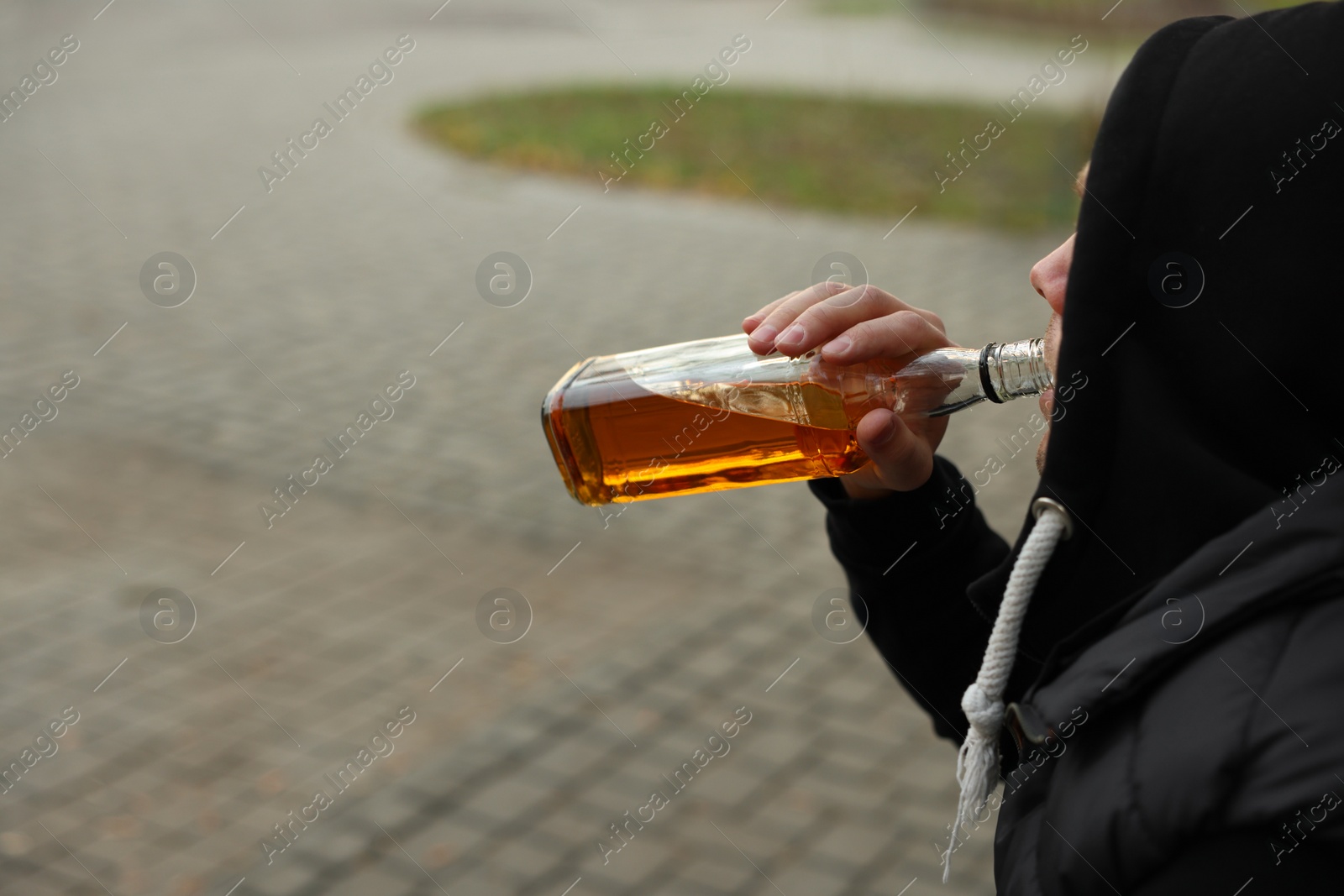 Photo of Addicted man drinking alcohol outdoors, closeup view