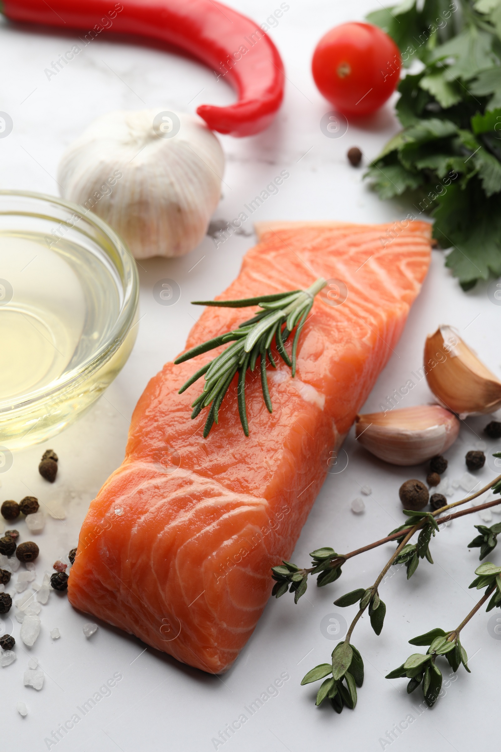 Photo of Fresh salmon and ingredients for marinade on white marble table