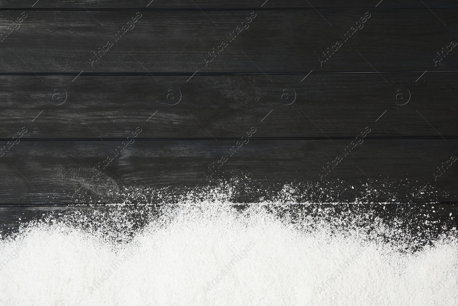 Photo of Artificial snow on black wooden background, top view with space for text. Christmas decor