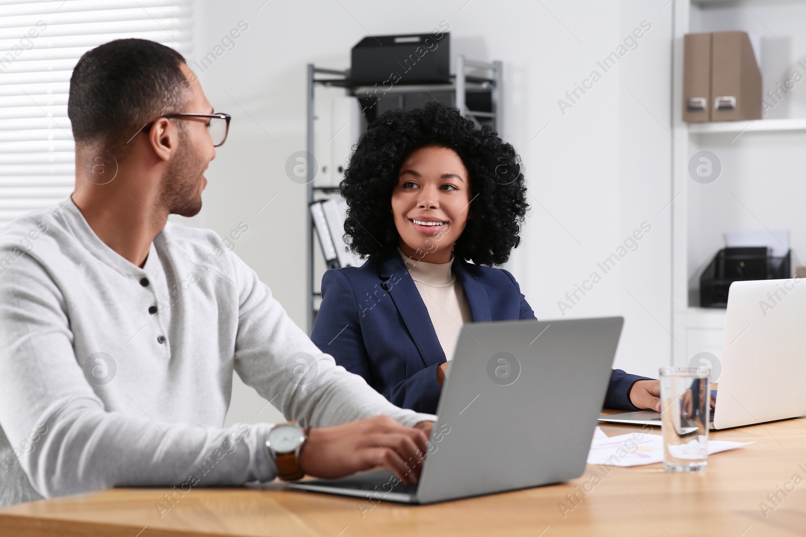 Photo of Young colleagues working together at table in office