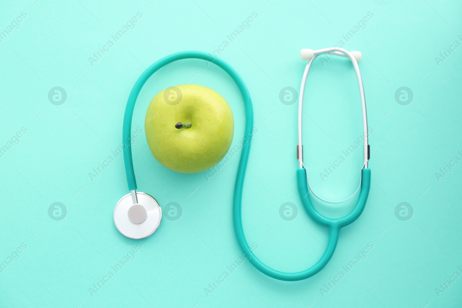 Photo of Flat lay composition with stethoscope and apple on color background