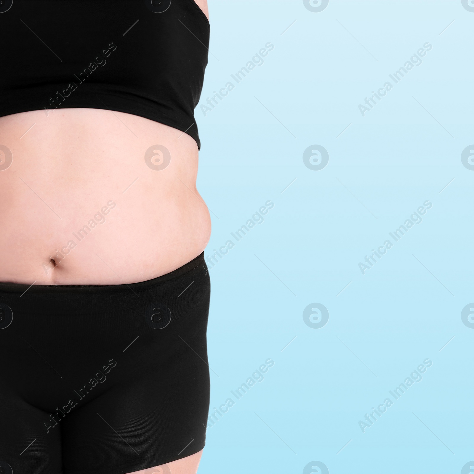 Image of Closeup view of overweight woman on light blue background, space for text