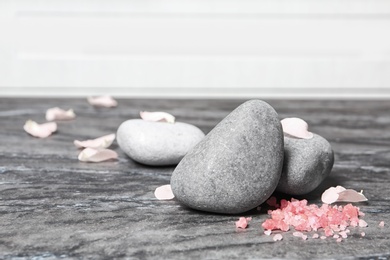 Spa stones, sea salt and flower petals on marble table
