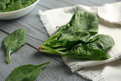 Photo of Fresh green healthy spinach leaves on grey wooden table, closeup