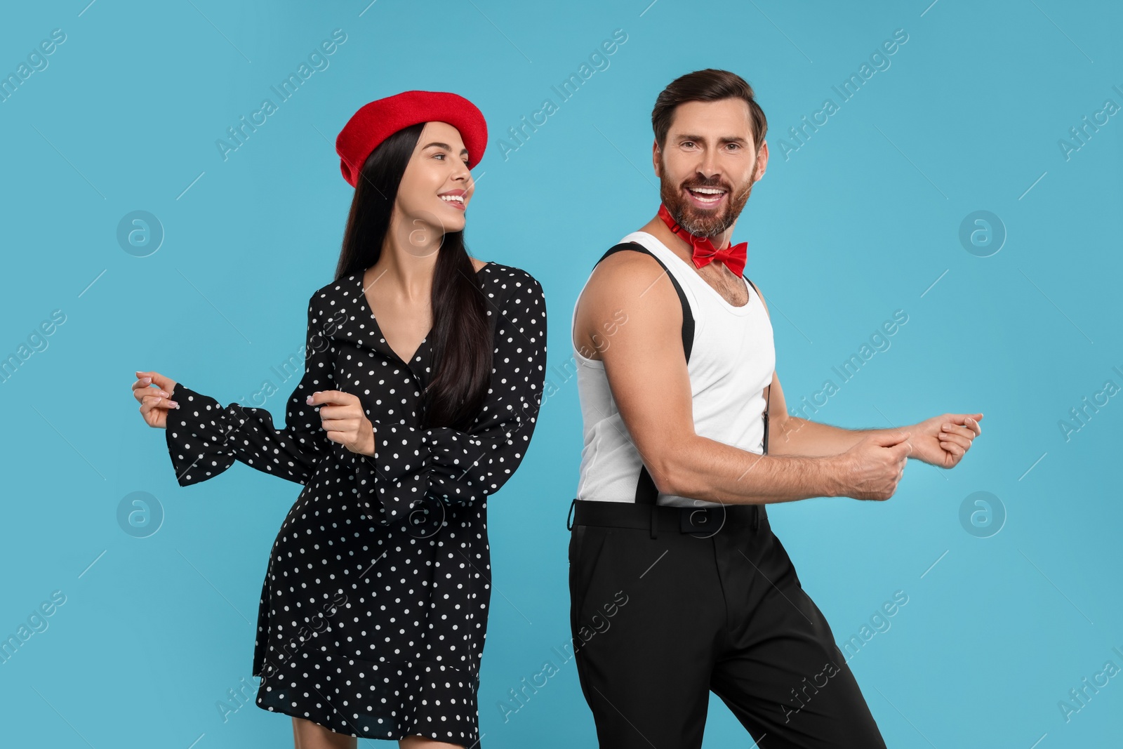 Photo of Happy couple dancing together on light blue background