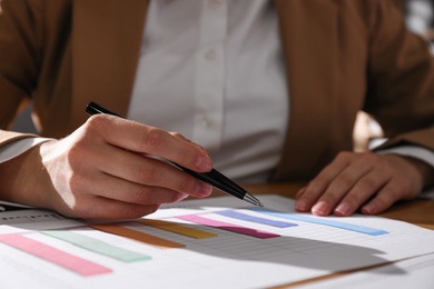 Photo of Businesswoman working with charts and graphs at table in office, closeup. Investment analysis