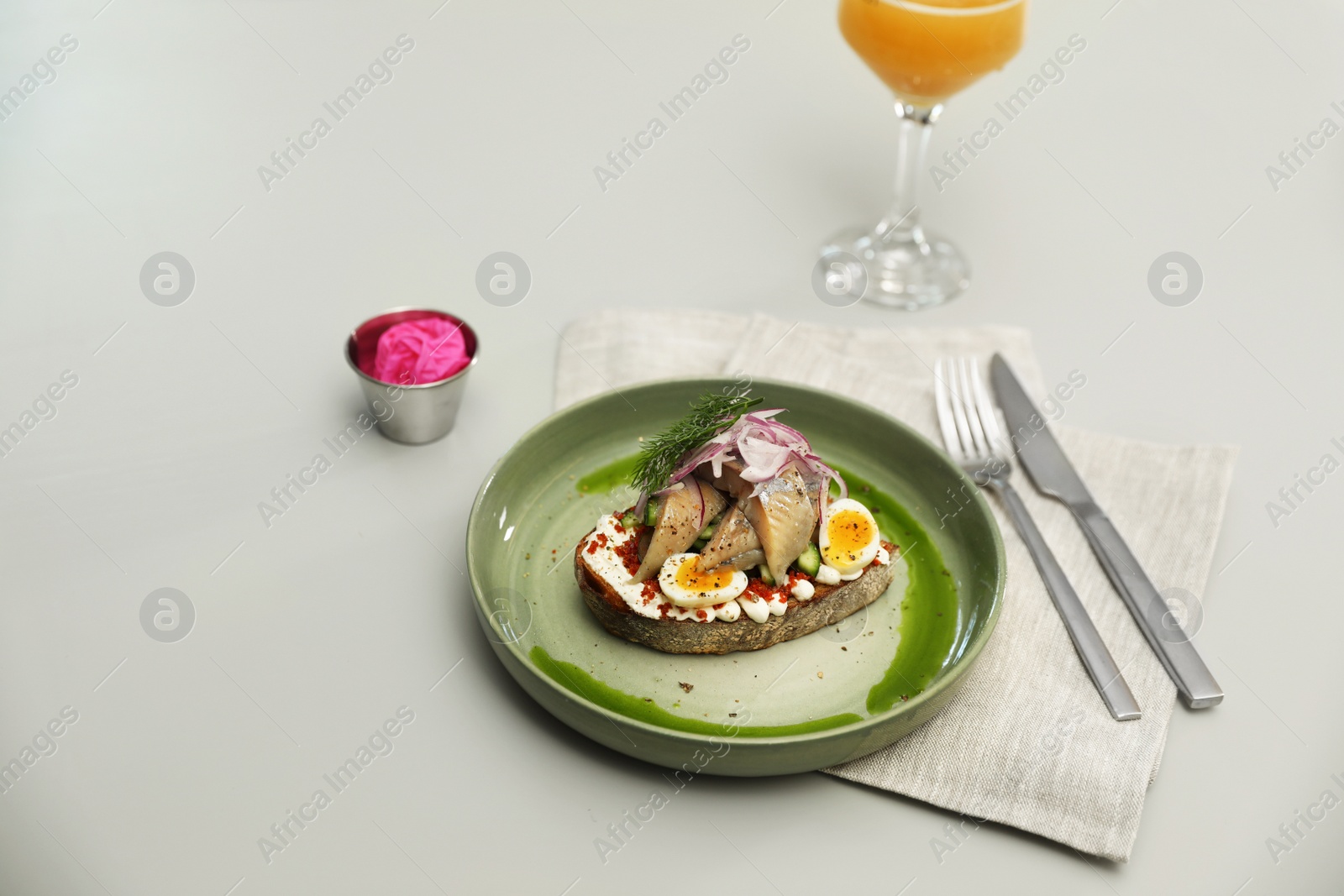 Photo of Tasty fish sandwich and glass of beer on light table