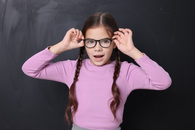 Photo of Back to school. Cute girl in glasses near chalkboard