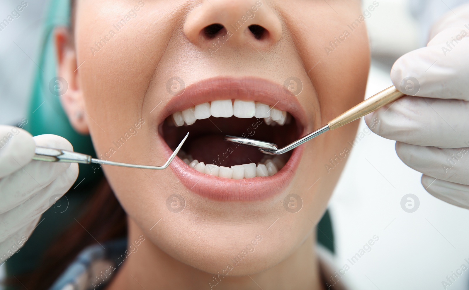 Photo of Professional dentist working with patient in hospital, closeup