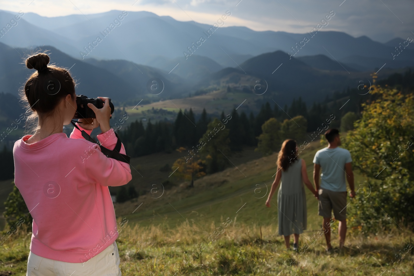 Photo of Professional photographer taking picture of couple in mountains