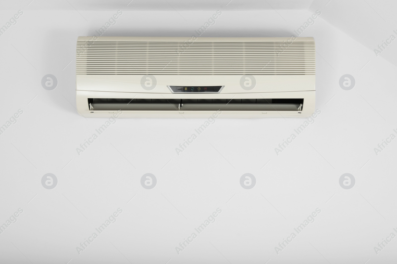 Photo of Modern air conditioner on white wall indoors