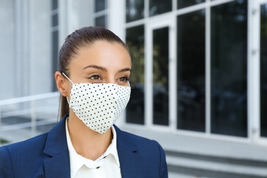 Photo of Woman wearing handmade cloth mask outdoors, space for text. Personal protective equipment during COVID-19 pandemic