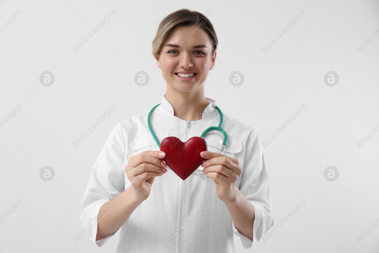 Photo of Doctor with stethoscope and red heart on white background. Cardiology concept