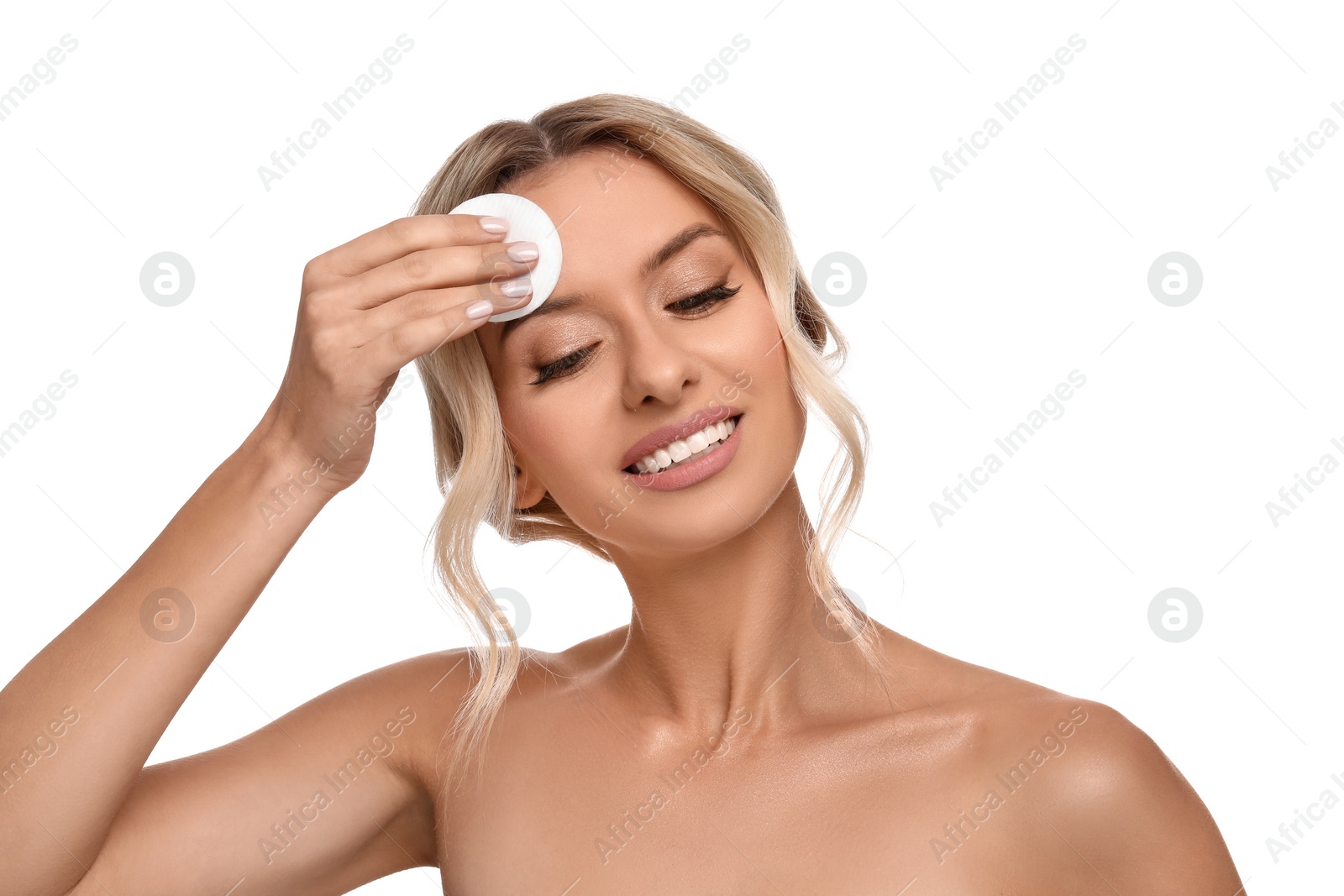 Photo of Smiling woman removing makeup with cotton pad on white background