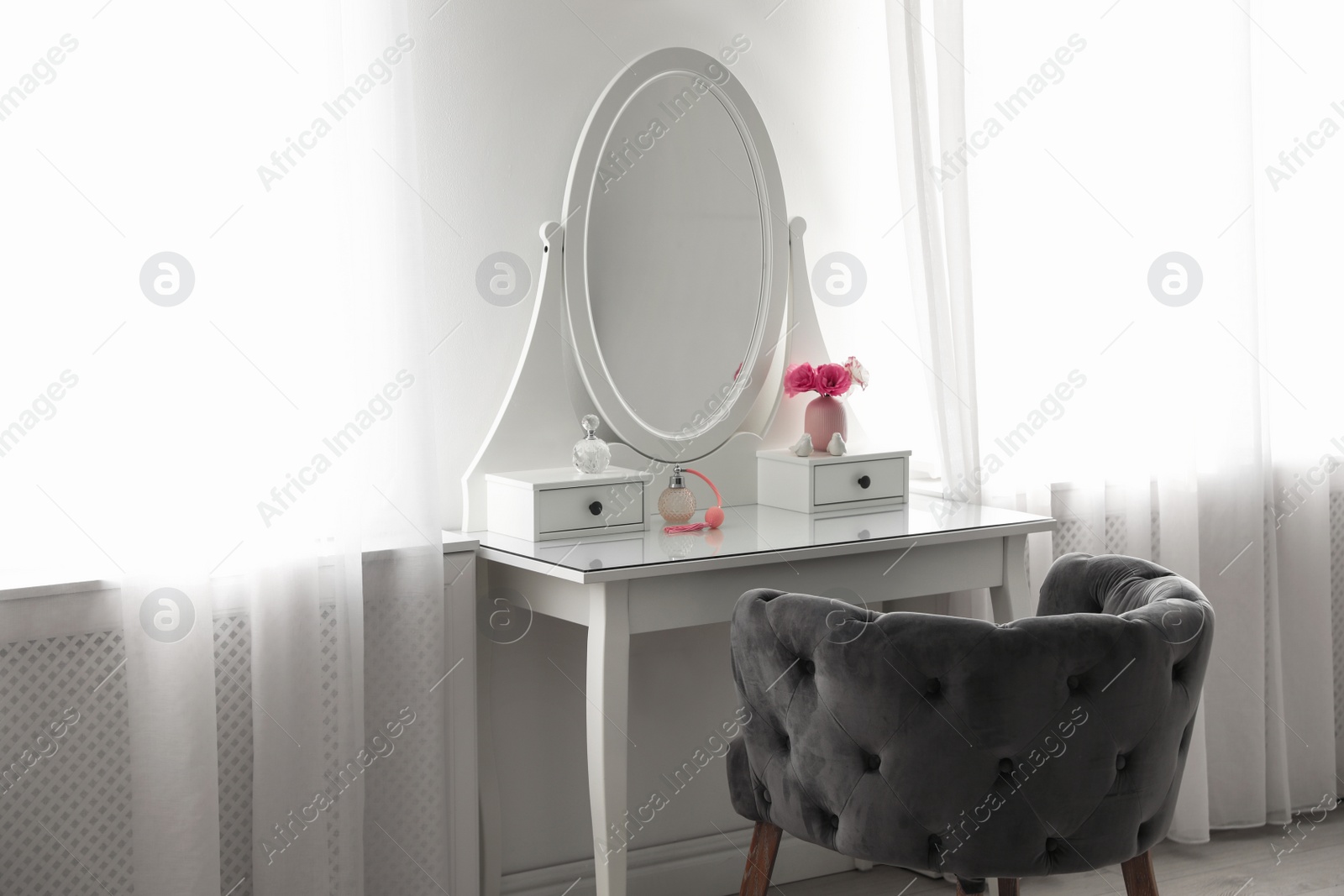 Photo of Elegant white dressing table and armchair in light room