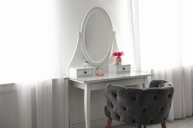 Elegant white dressing table and armchair in light room