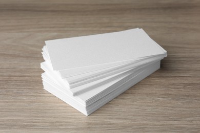 Stack of blank business cards on wooden table. Mockup for design