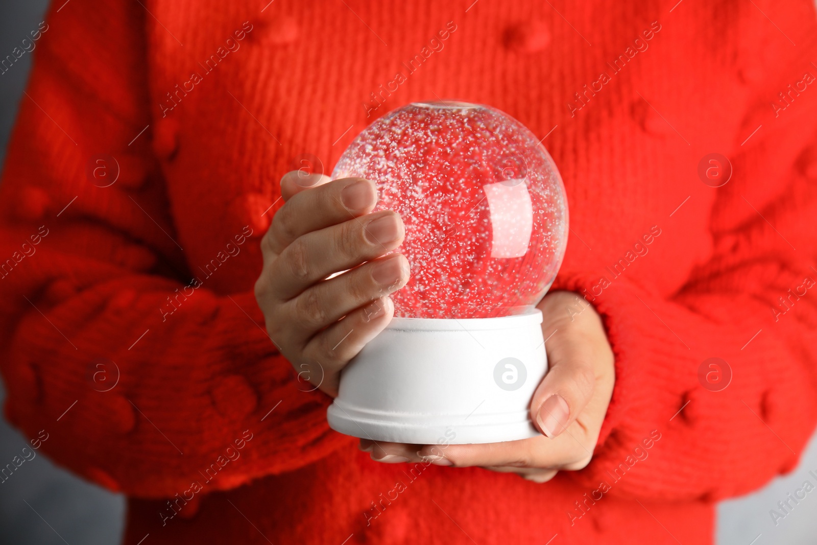 Photo of Woman holding magical empty snow globe, closeup