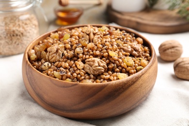 Fresh tasty traditional kutia in wooden bowl on light towel, closeup