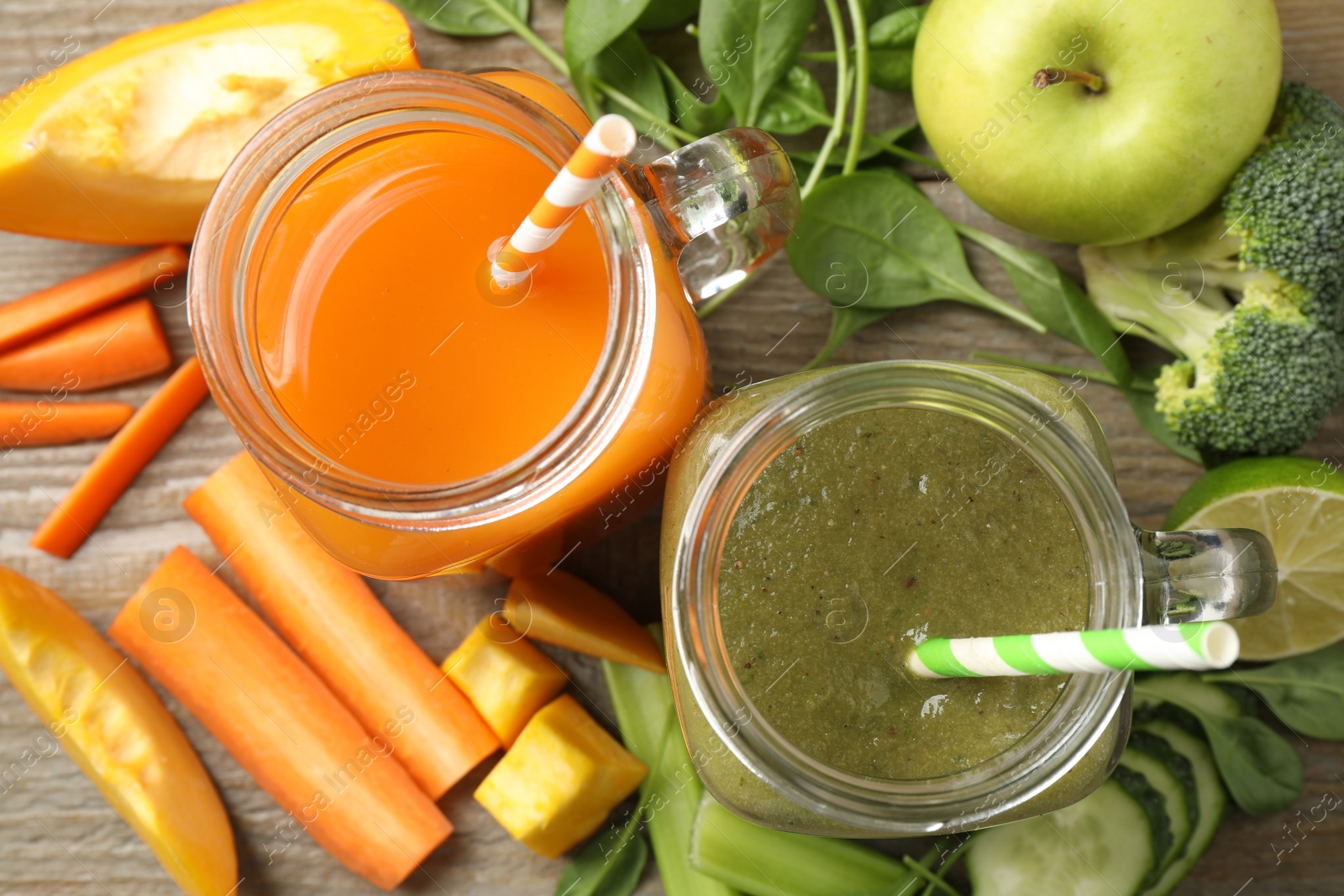 Photo of Delicious vegetable juices and fresh ingredients on wooden table, flat lay