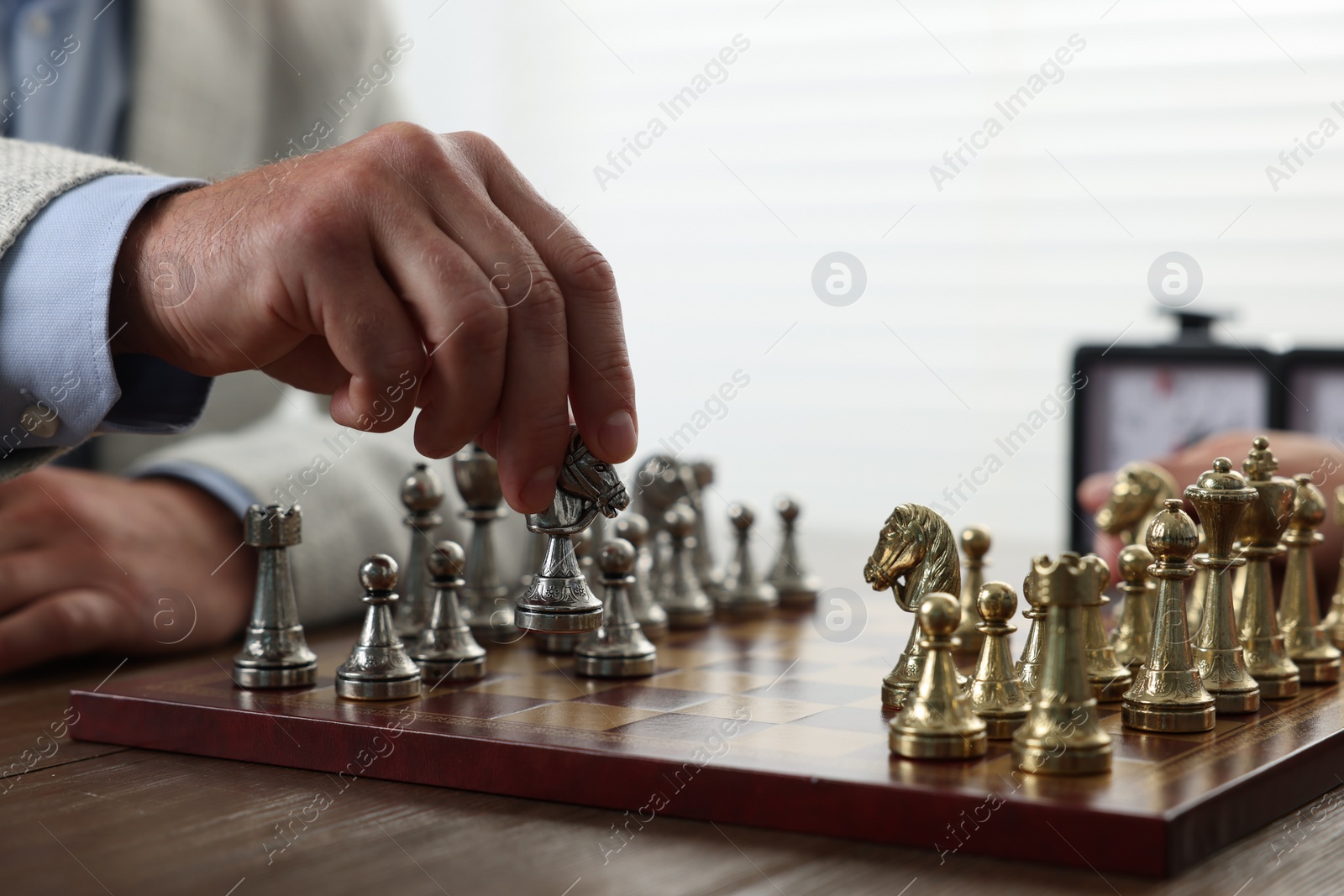 Photo of Man playing chess during tournament at table, closeup