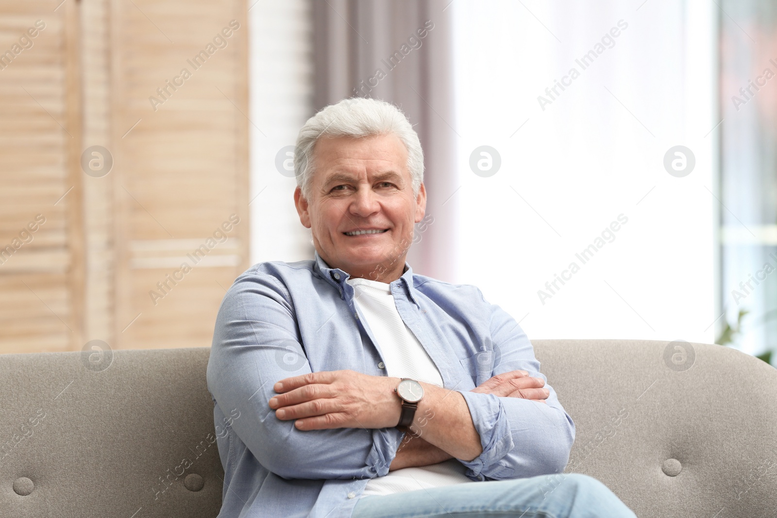 Photo of Portrait of handsome mature man on sofa indoors