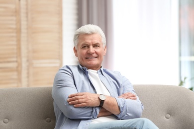 Photo of Portrait of handsome mature man on sofa indoors