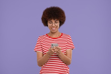 Photo of Happy young woman with smartphone on purple background