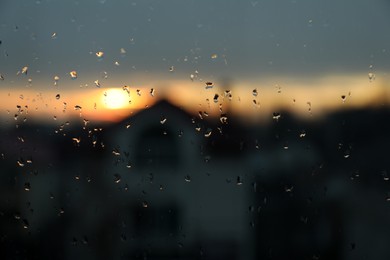 Photo of Blurred view of city through window on rainy day