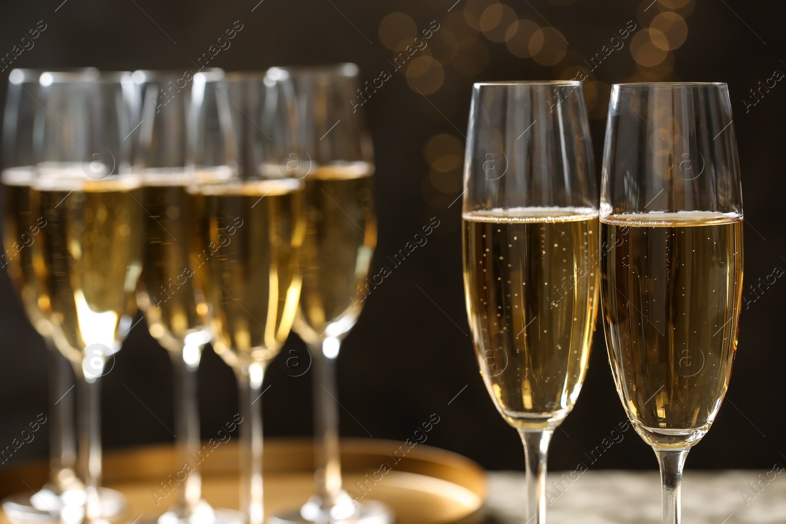 Photo of Glasses of champagne on blurred background, closeup. Space for text