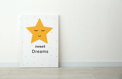Photo of Adorable picture of star with words SWEET DREAMS on floor near white wall, space for text. Children's room interior element