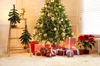 Many different gifts under Christmas tree indoors