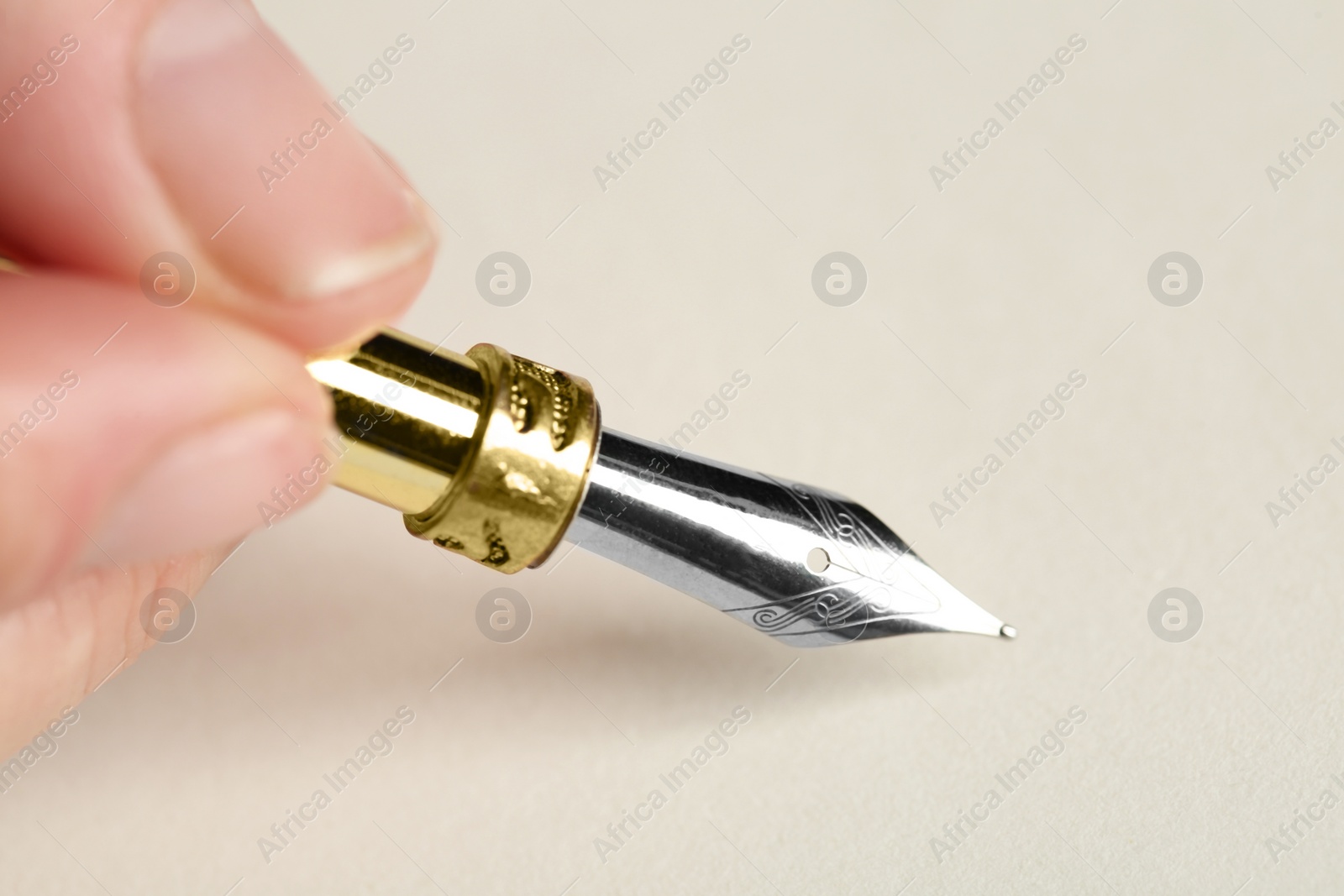 Photo of Woman with fountain pen above light paper, closeup