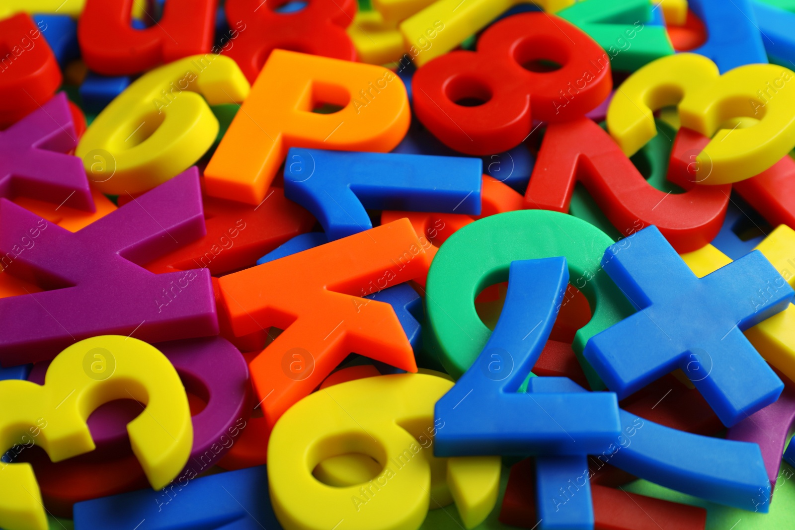 Photo of Colorful plastic magnetic letters and numbers as background, closeup