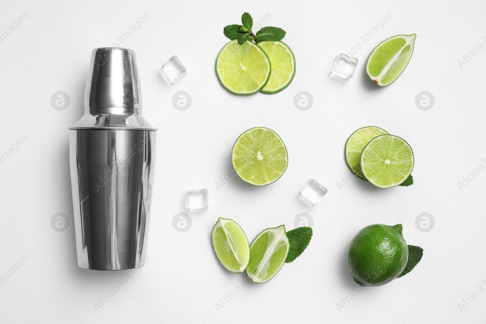 Photo of Flat lay composition with fresh juicy limes, ice cubes and cocktail shaker on white background