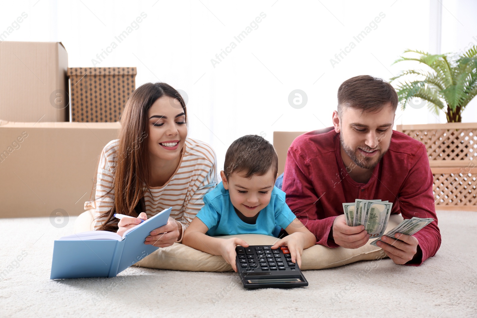 Photo of Happy family with money on floor at home