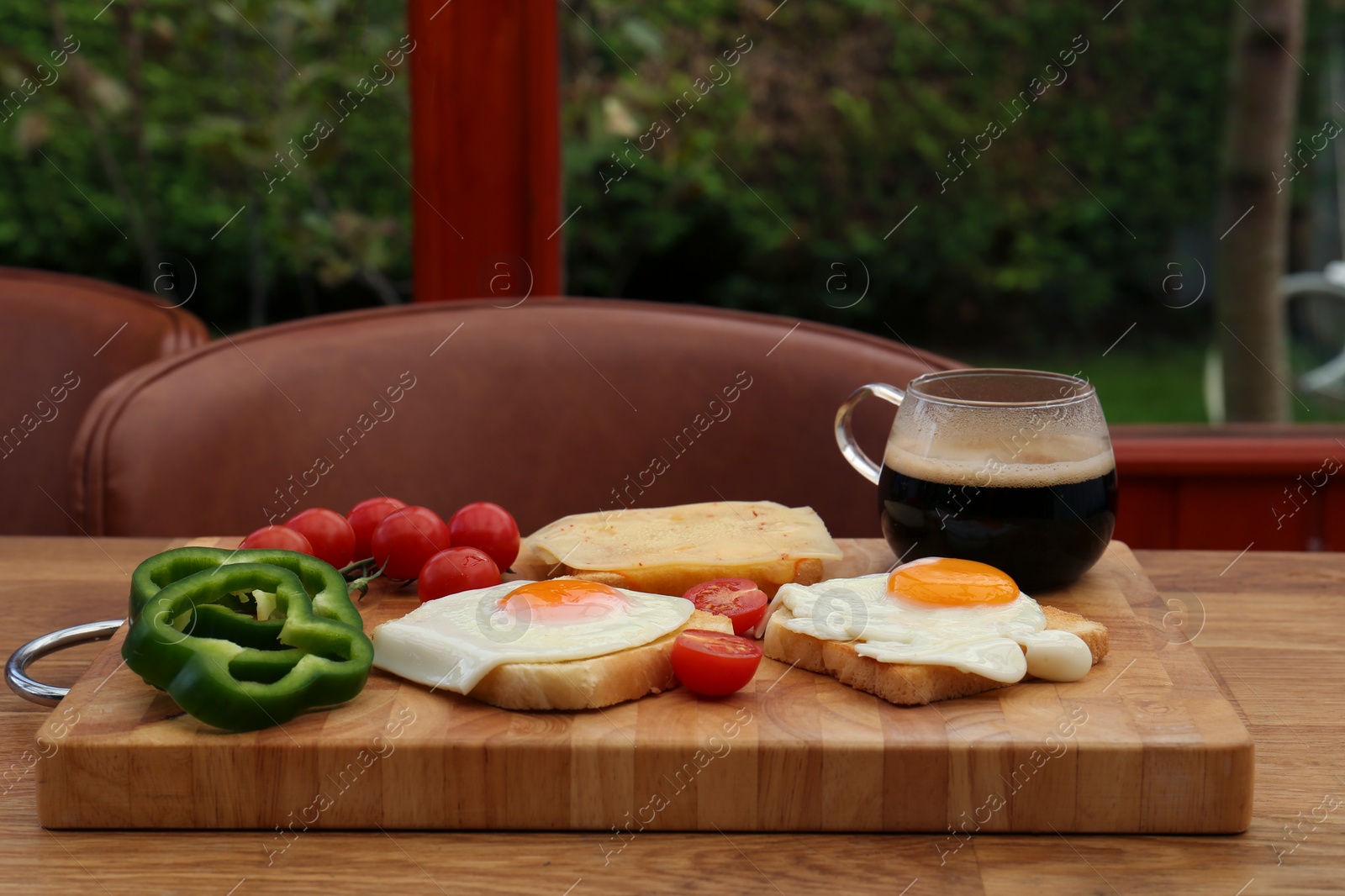 Photo of Tasty toasts with fried eggs, cheese and vegetables on wooden table indoors