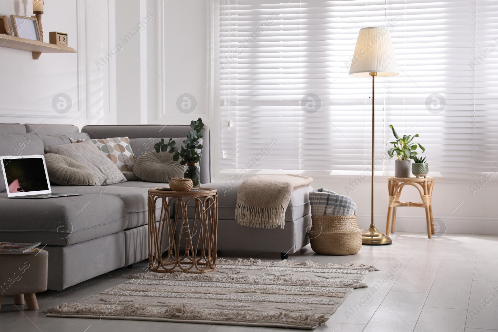 Photo of Living room with comfortable grey sofa and stylish interior elements near window