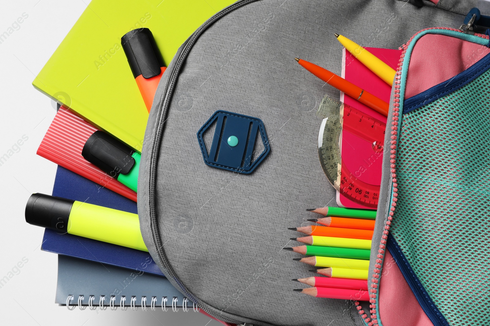 Photo of Backpack with different school stationery on white background, top view