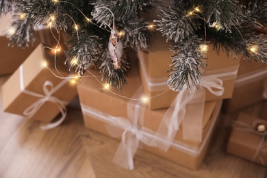 Beautiful decorated Christmas tree with gifts in room, closeup