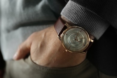 Photo of Man wearing luxury wrist watch with leather band, closeup