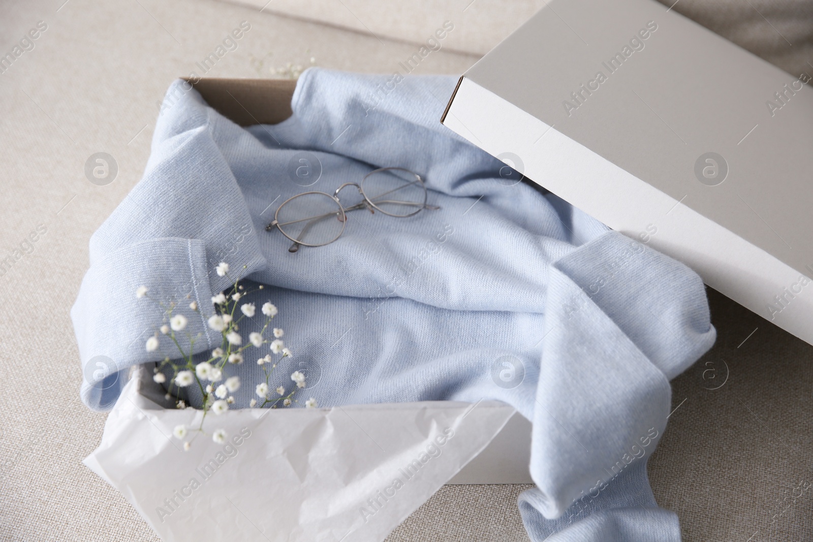 Photo of Soft cashmere sweater in box on sofa