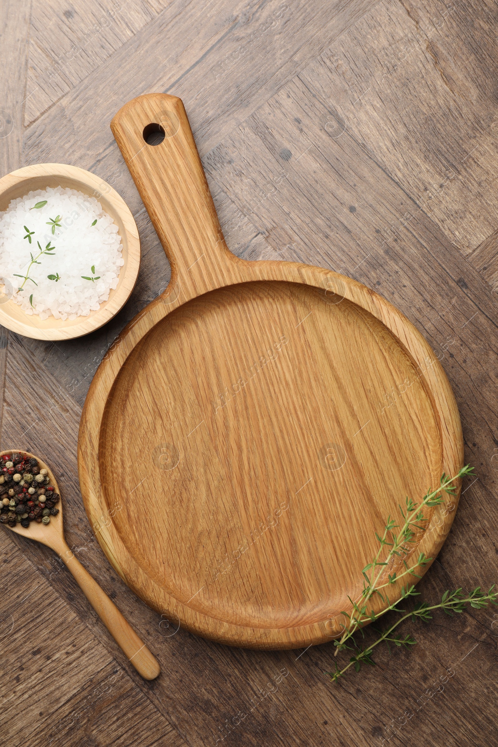 Photo of Cutting board and different spices on wooden table, flat lay